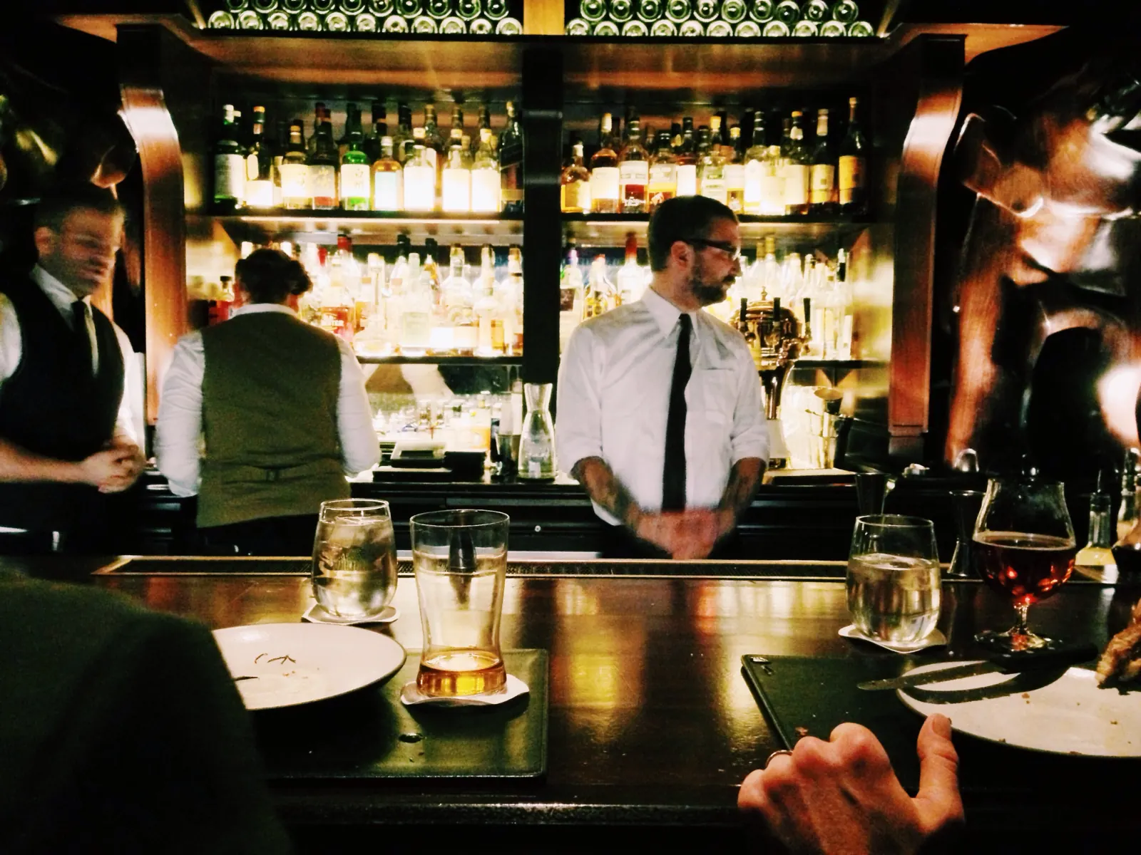 Bartenders working behind a busy bar